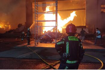 Los bomberos de Alcalá vigilan el incendio declarado en una nave de reciclado de la ciudad para asegurar su extinción